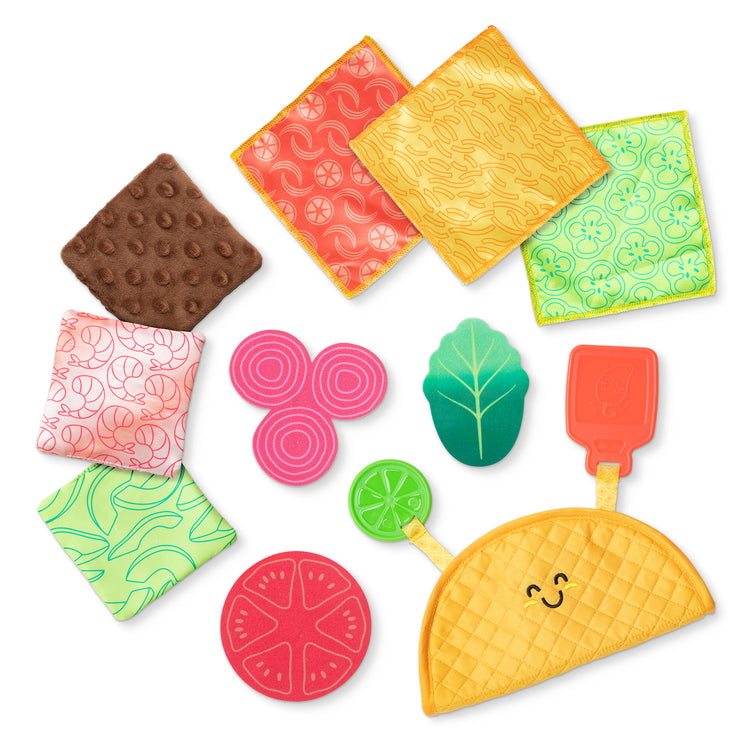 The loose pieces of The Melissa & Doug Multi-Sensory Soft Taco Fill & Spill Infant Toy