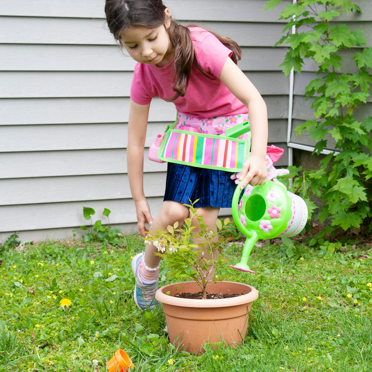 A kid playing with The Melissa & Doug Sunny Patch Pretty Petals Flower Watering Can - Pretend Play Toy