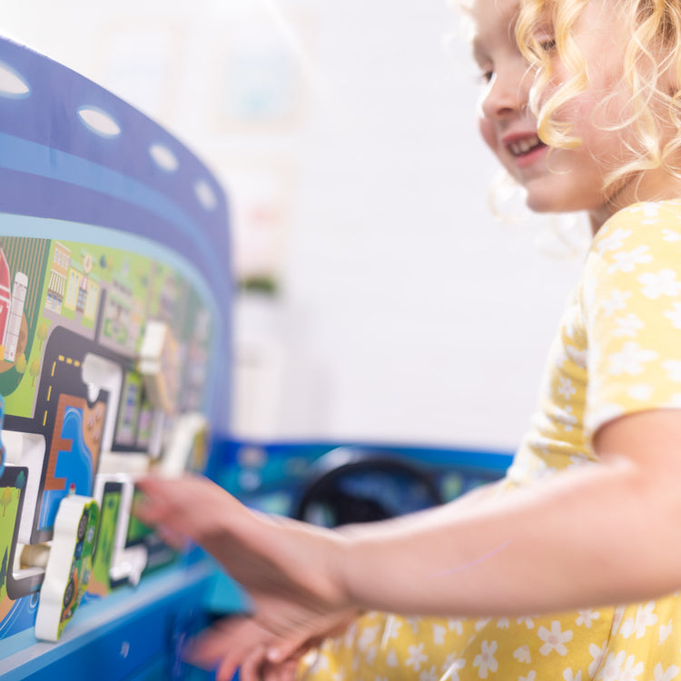 A kid playing with The Melissa & Doug PAW Patrol Wooden PAW Patroller Activity Center Multi-Sided Play Space