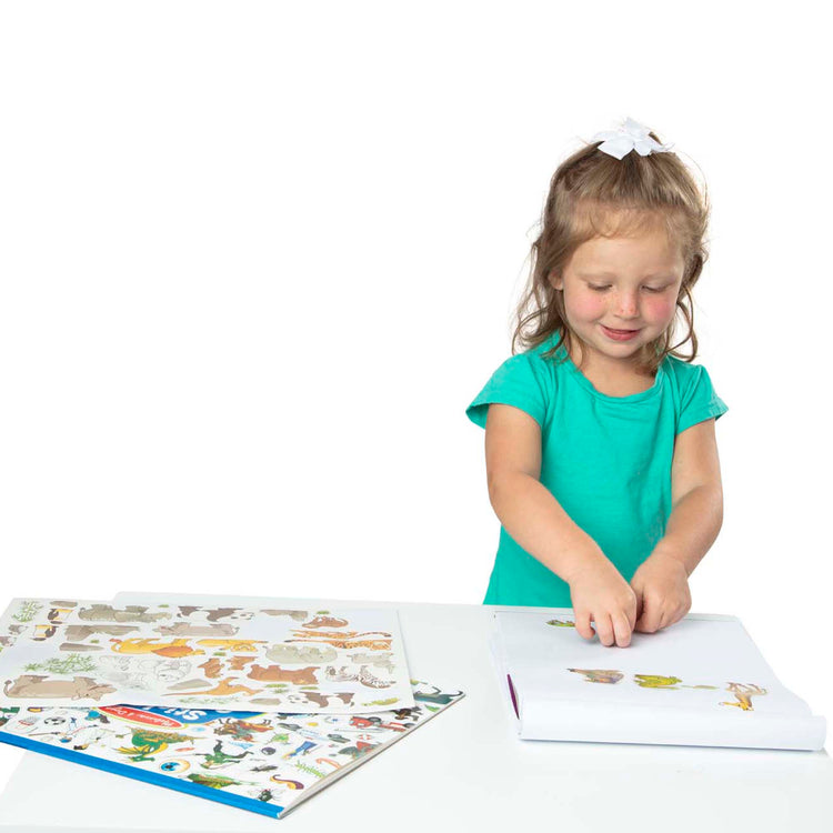 A child on white background with The Melissa & Doug Sticker Collection Book: Dinosaurs, Vehicles, Space, and More - 500+ Stickers