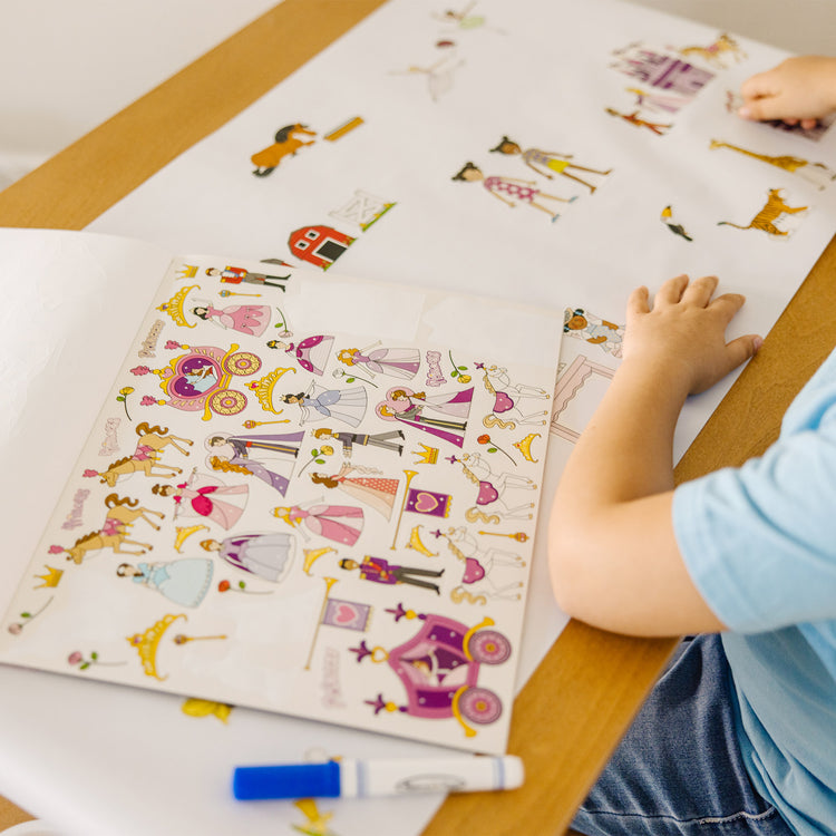 A kid playing with The Melissa & Doug Sticker Collection Book: Princesses, Tea Party, Animals, and More - 500+ Stickers