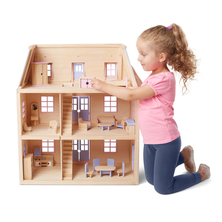 A child on white background with The Melissa & Doug Modern Wooden Multi-Level Dollhouse With 19 pcs Furniture [White]