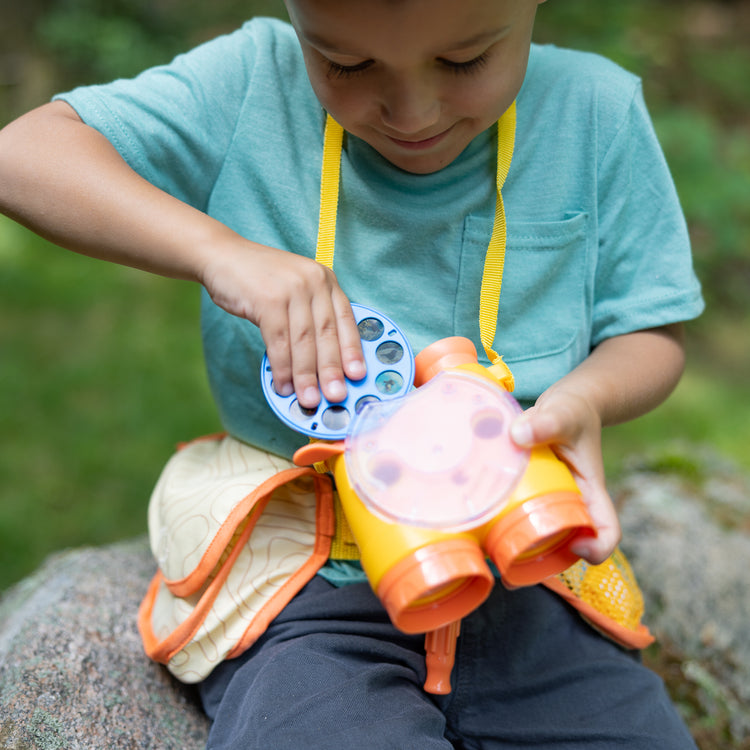 A kid playing with The Melissa & Doug Grand Canyon National Park Hiking Gear Play Set with Photo Disk Viewer