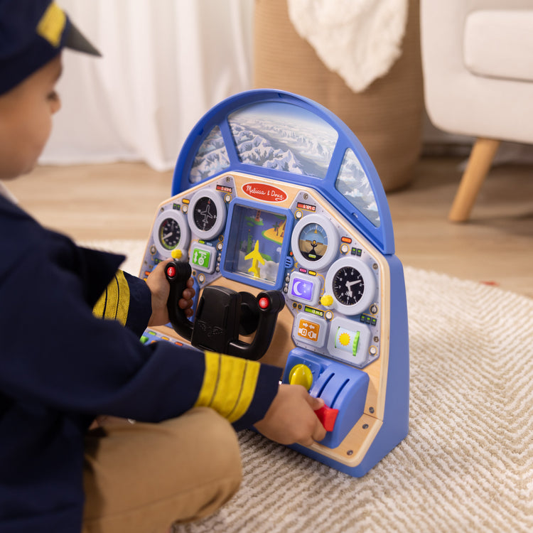 A kid playing with The Melissa & Doug Jet Pilot Interactive Dashboard Wooden Toy for Boys and Girls Ages 3+