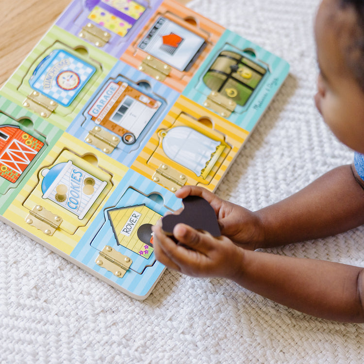 A kid playing with The Melissa & Doug Hide and Seek Wooden Activity Board With Wooden Magnets