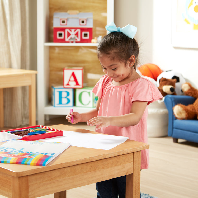 A kid playing with The Melissa & Doug Drawing Pad (9 x 12 inches) With 50 Sheets of White Bond Paper