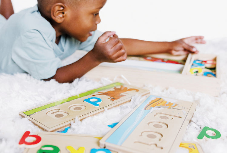 child playing with wooden see & spell learning toy