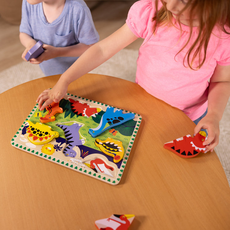 A kid playing with The Melissa & Doug Dinosaur Wooden Chunky Puzzle (7 pcs)