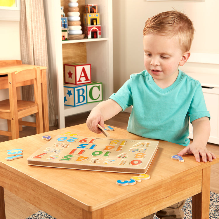 A kid playing with The Melissa & Doug Numbers Sound Puzzle - Wooden Counting Puzzle With Sound Effects (21 pcs)