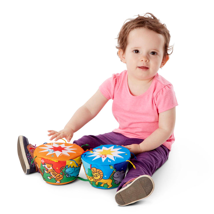 A child on white background with The Melissa & Doug K's Kids Bongo Drums Soft Musical Instrument