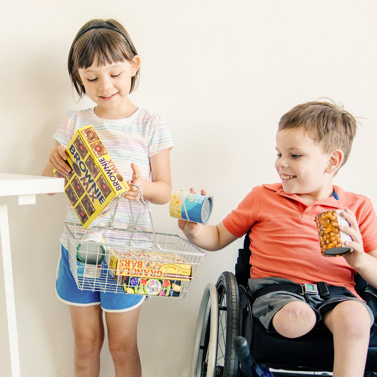 A kid playing with The Melissa & Doug Grocery Basket - Pretend Play Toy With Heavy Gauge Steel Construction