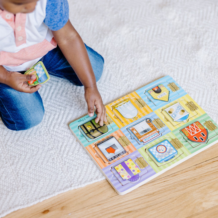 A kid playing with The Melissa & Doug Hide and Seek Wooden Activity Board With Wooden Magnets