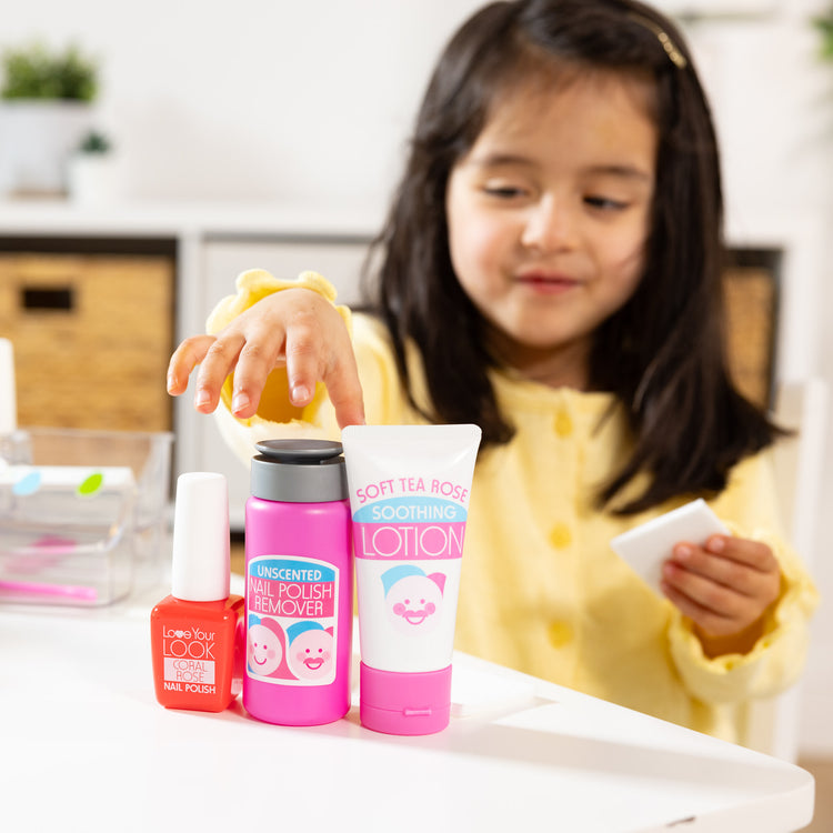 A kid playing with The Melissa & Doug Love Your Look Pretend Nail Care Play Set – 22 Pieces for Mess-Free Play Mani-Pedis (DOES NOT CONTAIN REAL COSMETICS)