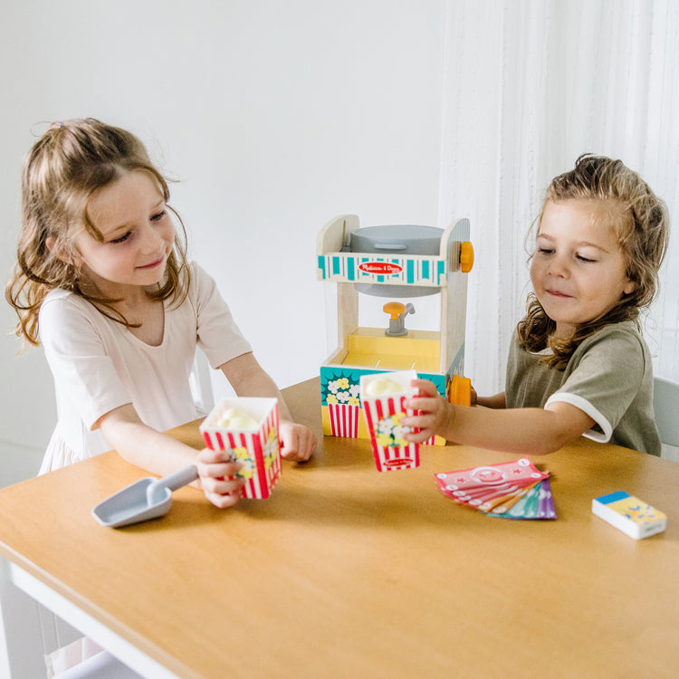 A kid playing with The Melissa & Doug Fun at the Fair! Wooden Popcorn Popping Play Food Set