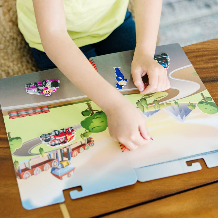 A kid playing with The Melissa & Doug PAW Patrol Restickable Puffy Stickers - Big Truck Pups