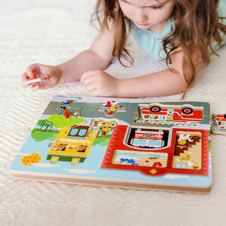 A kid playing with The Melissa & Doug Around the Fire Station Sound Puzzle - Wooden Peg Puzzle (8 pcs)