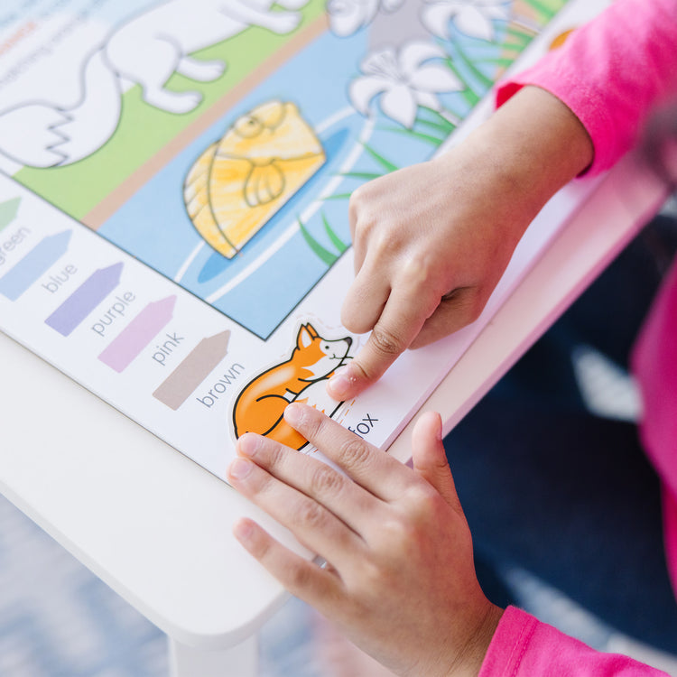 A kid playing with The Melissa & Doug Colors and Shapes Coloring and Sticker Activity Pad