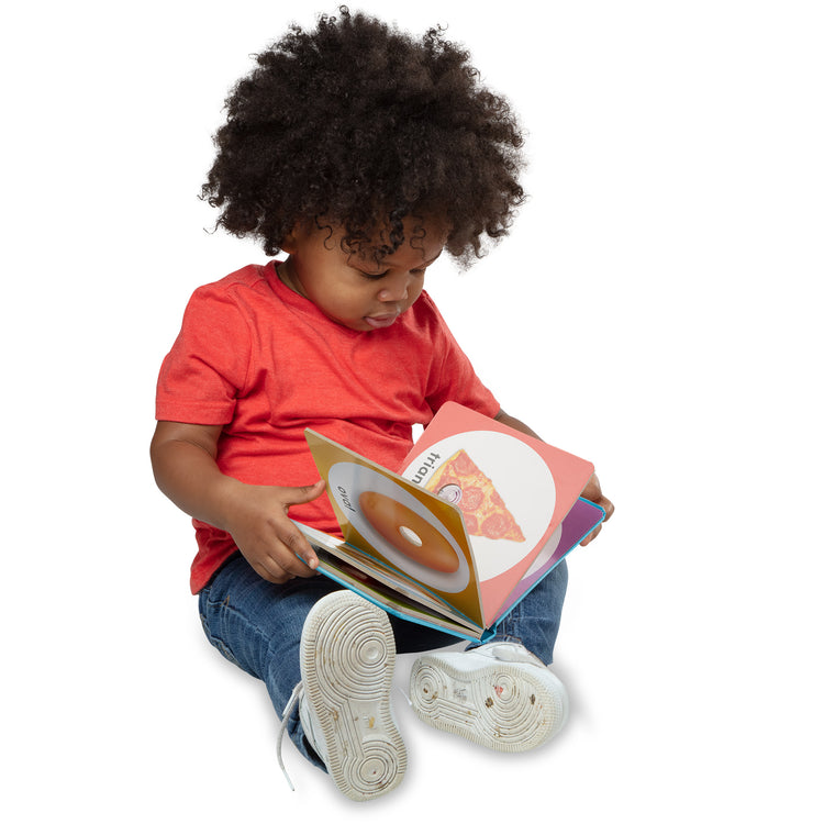 A kid playing with The Melissa & Doug Children’s Book – Poke-a-Dot: First Shapes (Board Book with Buttons to Pop)