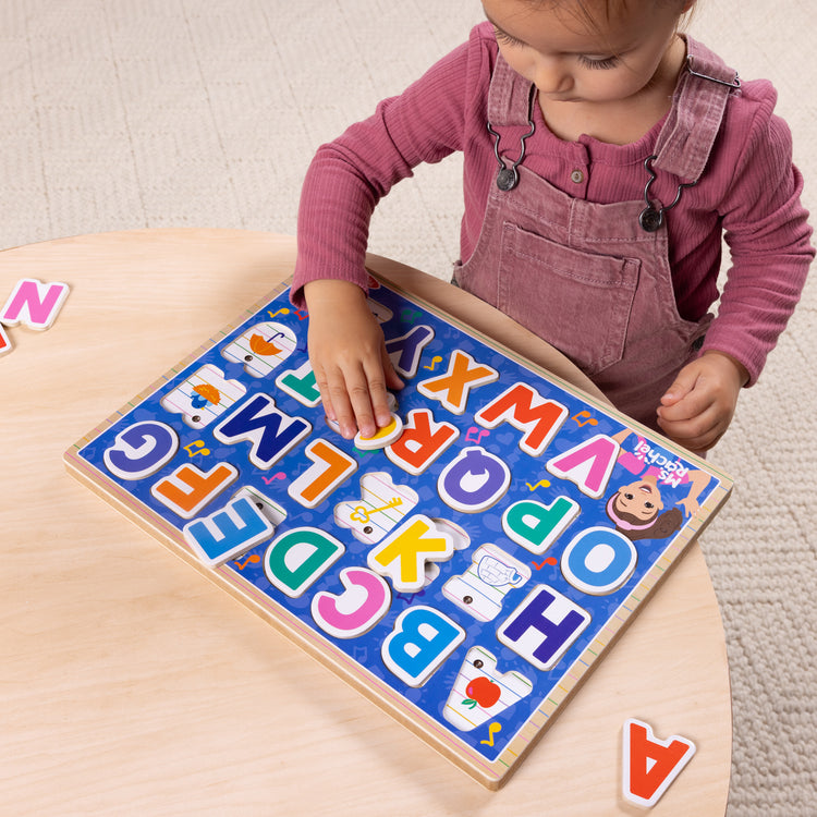 A kid playing with The Melissa & Doug® Ms. Rachel™ Wooden Phonics Alphabet Sound Puzzle, 24-Piece Toddler Toys for Boys and Girls Ages 2+ Years