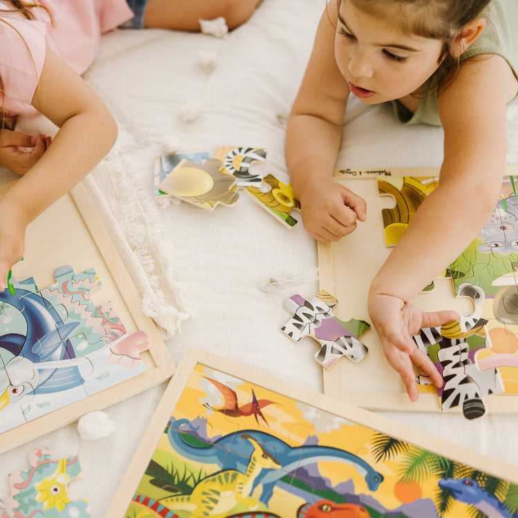 A kid playing with The Melissa & Doug Jigsaw Puzzle Bundle (Dinosaur,Safari and Ocean)