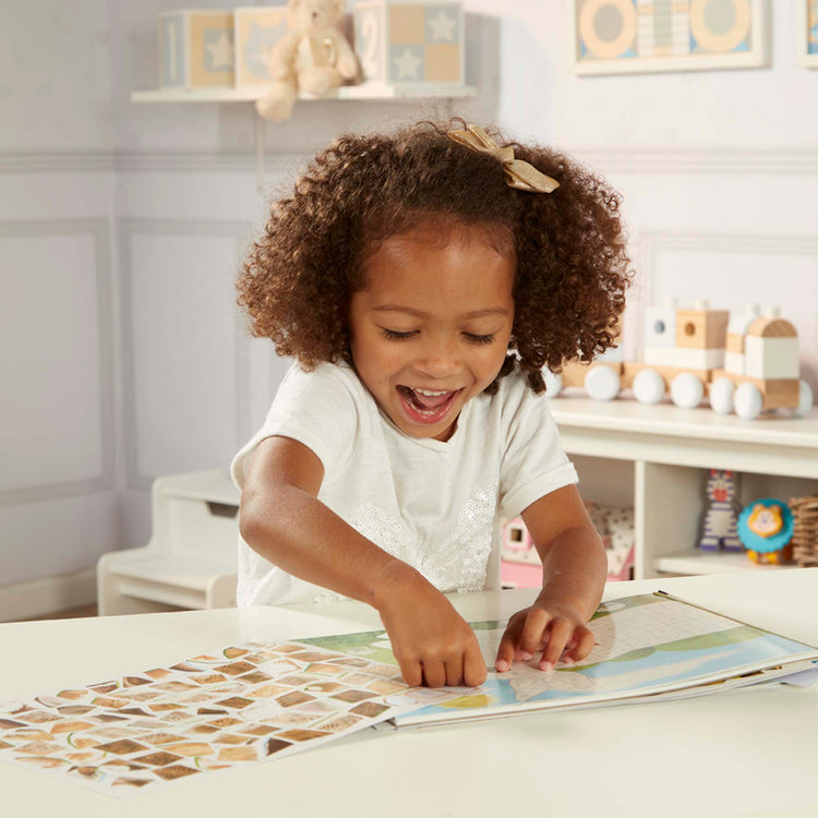 A kid playing with The Melissa & Doug Mosaic Sticker Pad Nature (12 Color Scenes to Complete with 850+ Stickers)