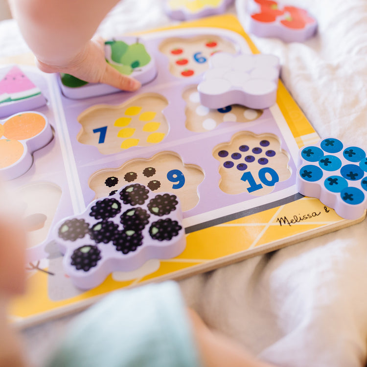 A kid playing with The Melissa & Doug Blue's Clues & You! Wooden Chunky Puzzle - Fridge Food (10 Pieces)