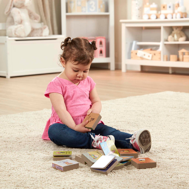 A kid playing with The Melissa & Doug Children's Book - Natural Play Book Tower: Little Nursery Books