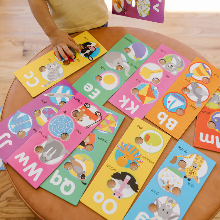 A kid playing with The Melissa & Doug Poke-a-Dot Alphabet Learning Cards