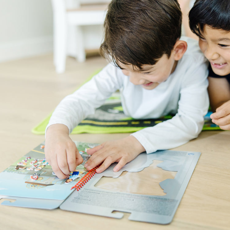 A kid playing with The Melissa & Doug PAW Patrol Restickable Puffy Stickers - Big Truck Pups