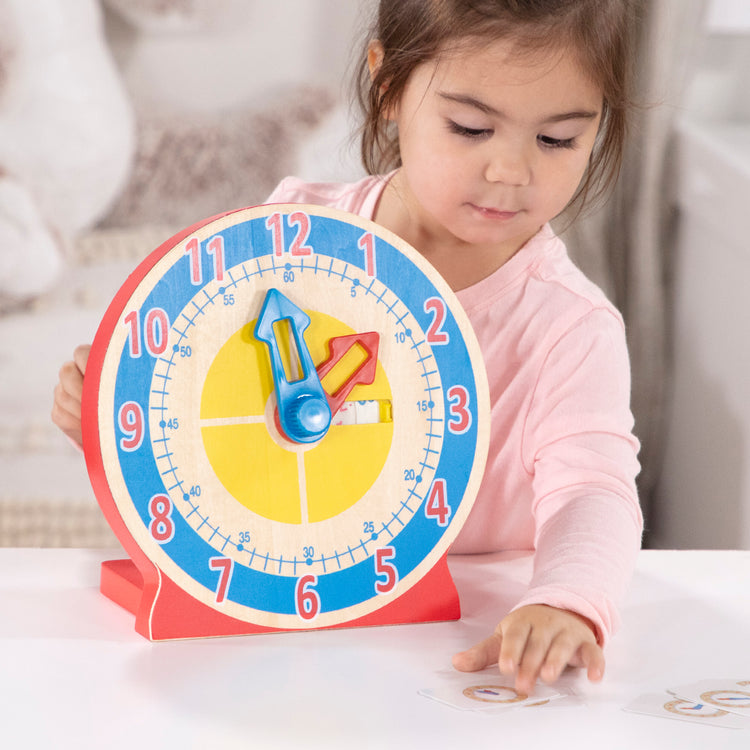 A kid playing with The Melissa & Doug Turn & Tell Wooden Clock - Educational Toy With 12+ Reversible Time Cards