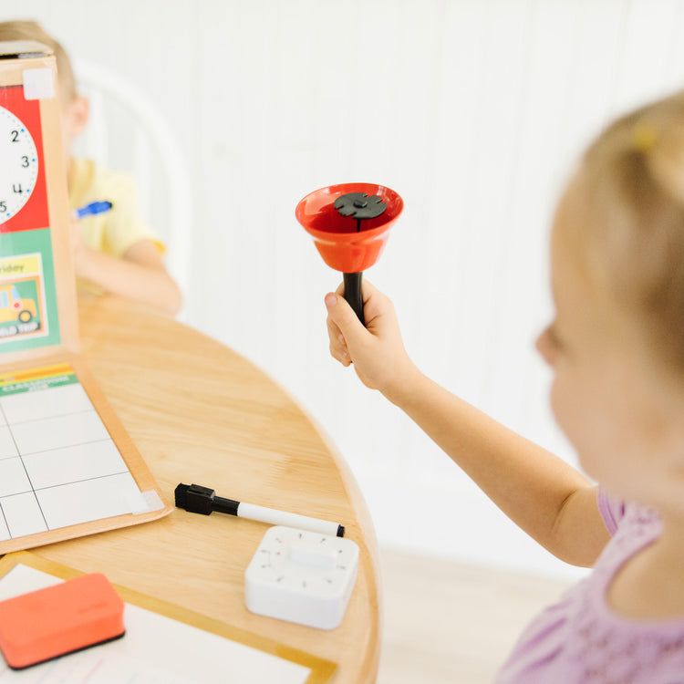 A kid playing with The Melissa & Doug School Time! Classroom Play Set Game - Be Teacher or Student