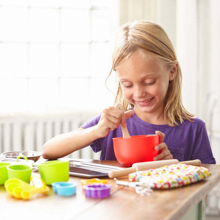 A kid playing with The Melissa & Doug Baking Play Set (20 pcs) - Play Kitchen Accessories