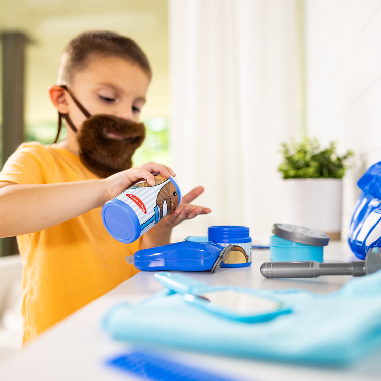 A kid playing with The Melissa & Doug Barber Shop Pretend Play Set Shaving Toy for Boys and Girls Ages 3+