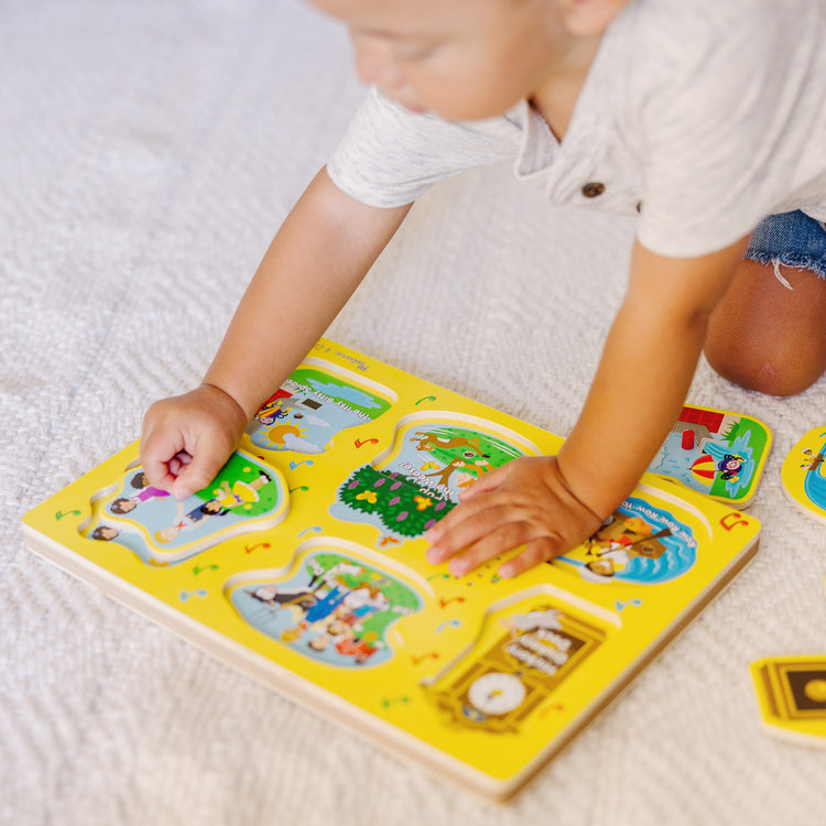 A kid playing with The Melissa & Doug Nursery Rhymes 1 Sound Puzzle - 6 PIeces