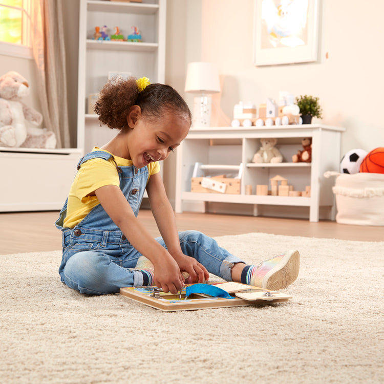 A kid playing with The Melissa & Doug Locks and Latches Board Wooden Educational Toy