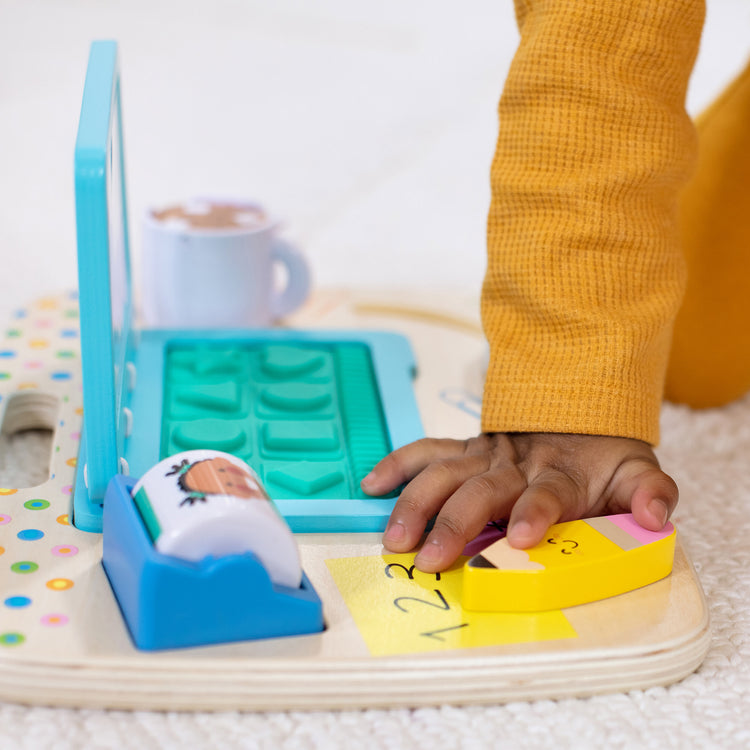 A kid playing with The Melissa & Doug Wooden Work & Play Desktop Activity Board Infant and Toddler Sensory Toy