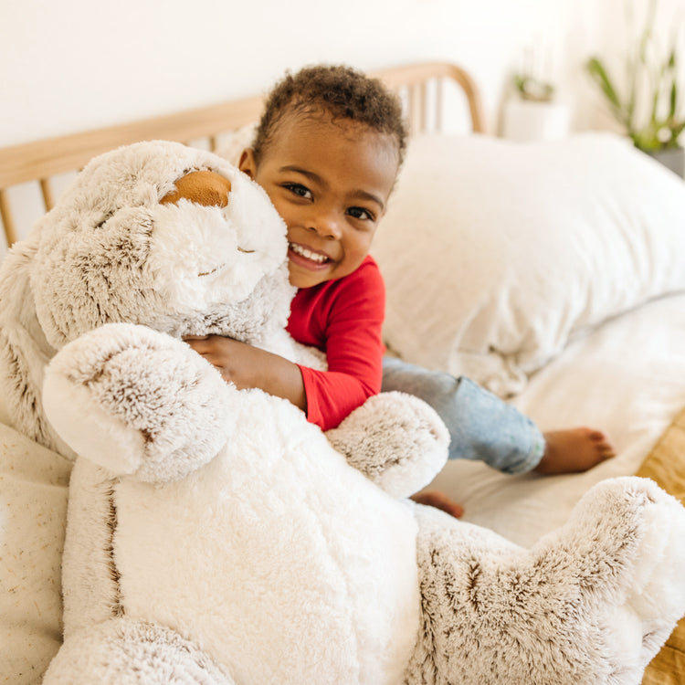 A kid playing with The Melissa & Doug Jumbo Burrow Bunny Lop-Eared Rabbit Stuffed Plush Animal (21 Inches Tall)