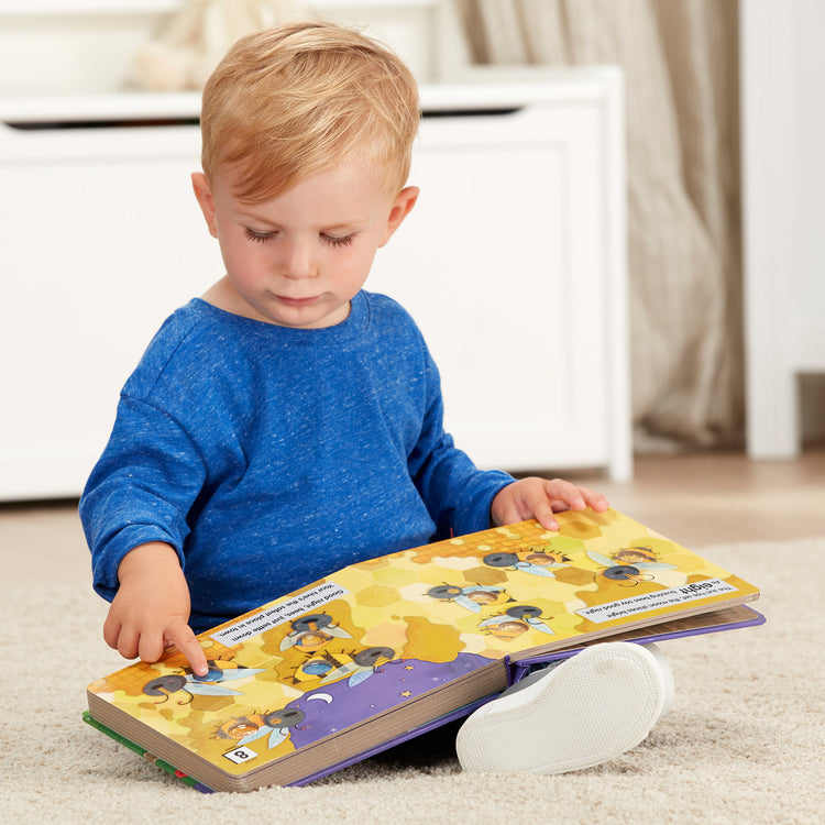 A kid playing with The Melissa & Doug Children's Book - Poke-a-Dot: Goodnight, Animals (Board Book with Buttons to Pop)