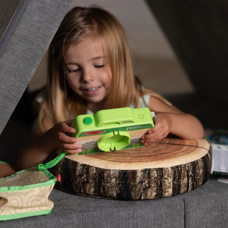 A kid playing with The Melissa & Doug Rocky Mountain National Park Sights and Sounds Wooden Toy Camera Play Set