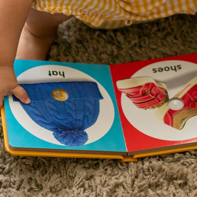 A kid playing with The Melissa & Doug Children’s Book – Poke-a-Dot: First Colors (Board Book with Buttons to Pop)