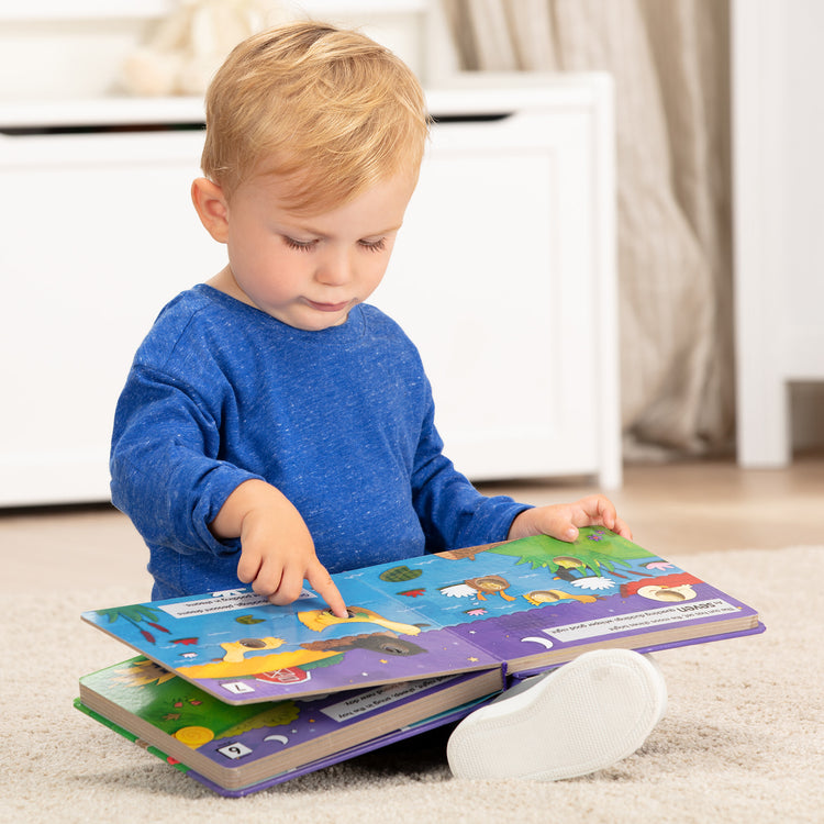 A kid playing with The Melissa & Doug Children's Book - Poke-a-Dot: Goodnight, Animals (Board Book with Buttons to Pop)