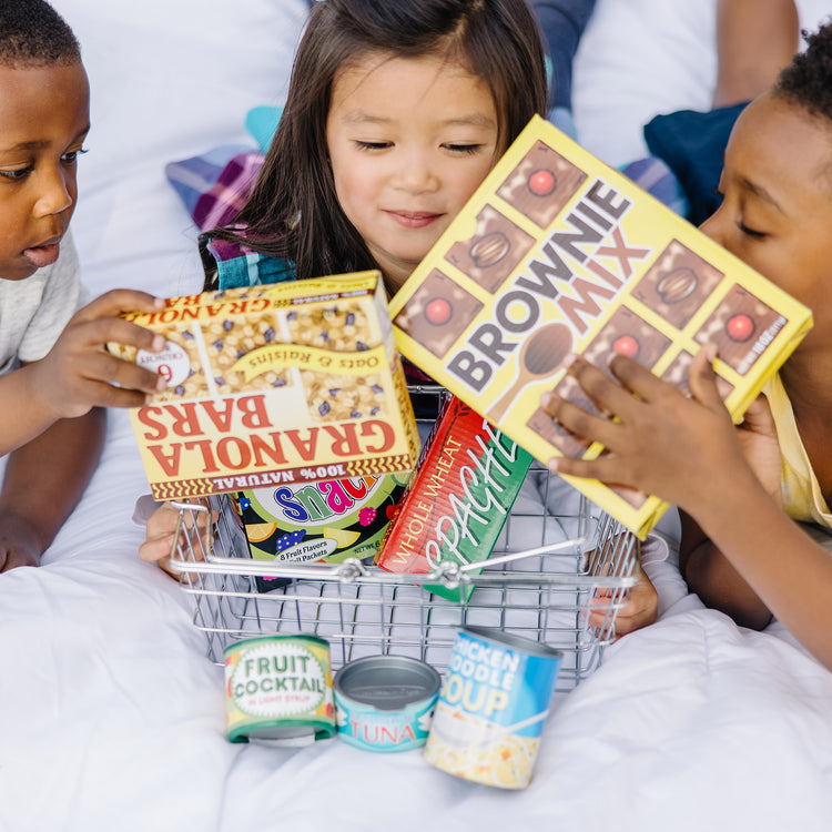 A kid playing with The Melissa & Doug Grocery Basket - Pretend Play Toy With Heavy Gauge Steel Construction