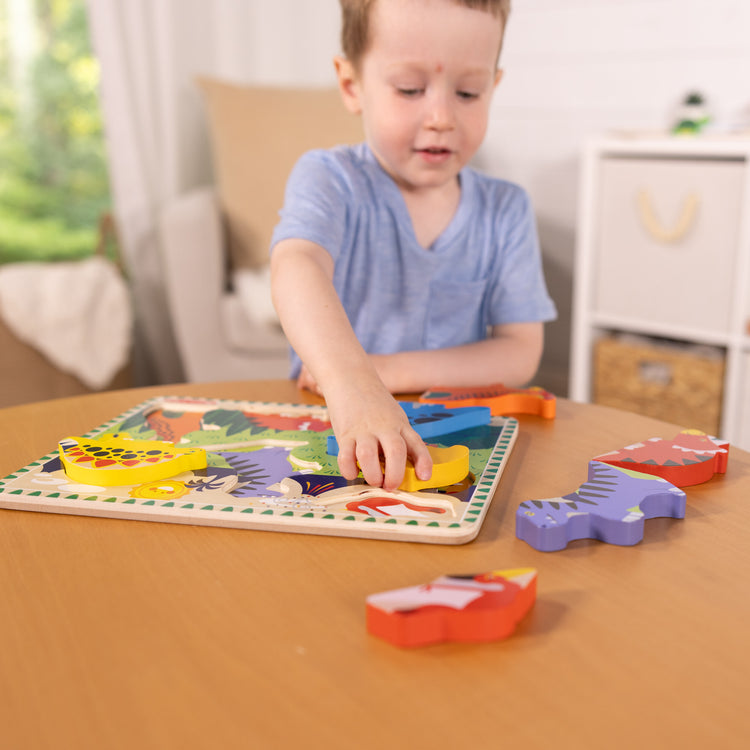 A kid playing with The Melissa & Doug Dinosaur Wooden Chunky Puzzle (7 pcs)