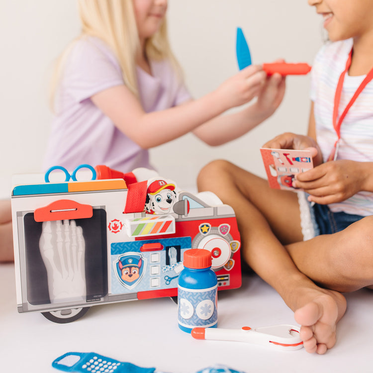 A kid playing with The Melissa & Doug PAW Patrol Marshall's Wooden Rescue EMT Caddy (14 Pieces)