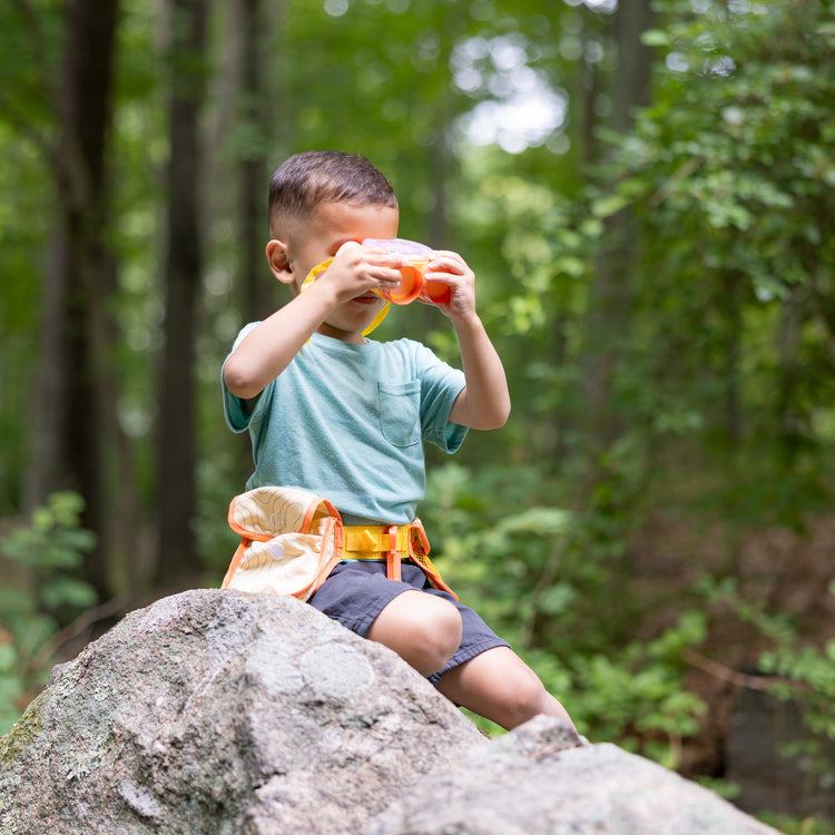 A kid playing with The Melissa & Doug Grand Canyon National Park Hiking Gear Play Set with Photo Disk Viewer