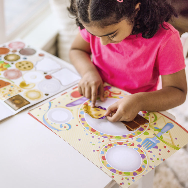 A kid playing with The Melissa & Doug Sticker Pad - Make-a-Meal, 225+ Food Stickers