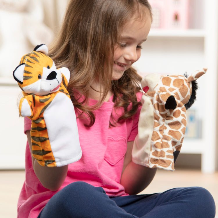 A kid playing with The Melissa & Doug Zoo Friends Hand Puppets (Set of 4) - Elephant, Giraffe, Tiger, and Monkey