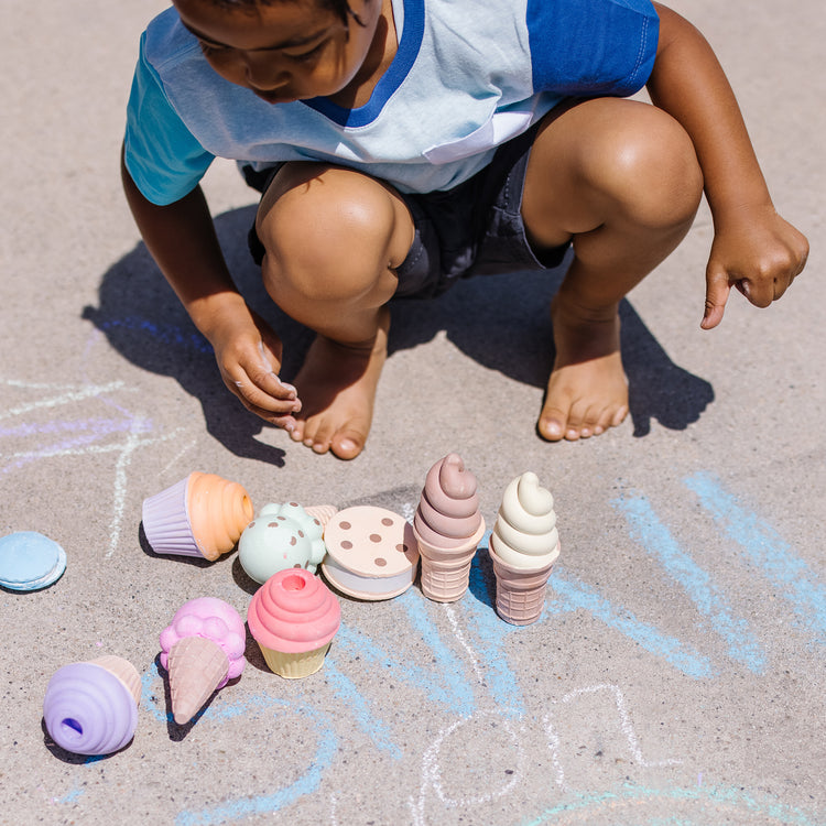 A kid playing with The Melissa & Doug Ice Cream & Cake Chalk Set