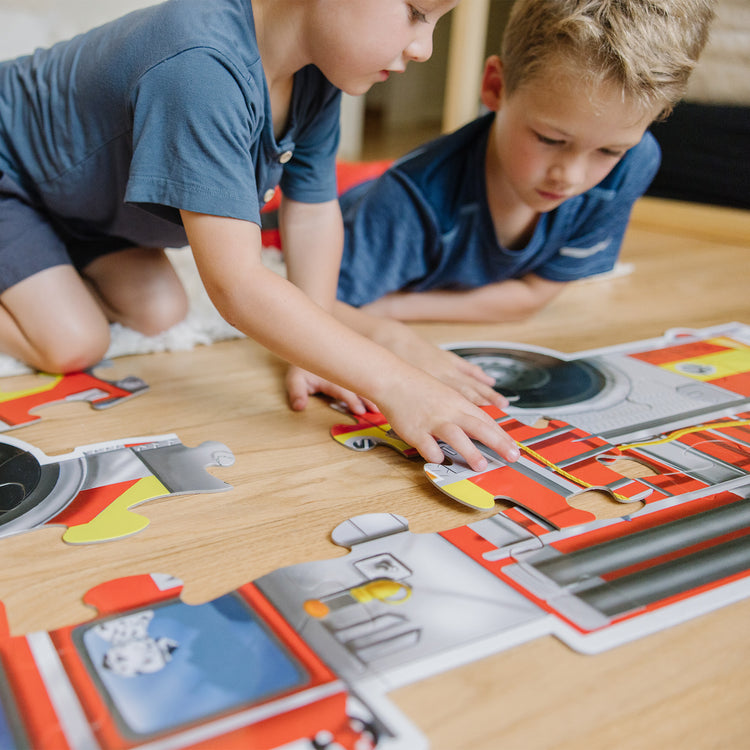 A kid playing with The Melissa & Doug Fire Truck Jumbo Jigsaw Floor Puzzle (24 pcs, 4 feet long)