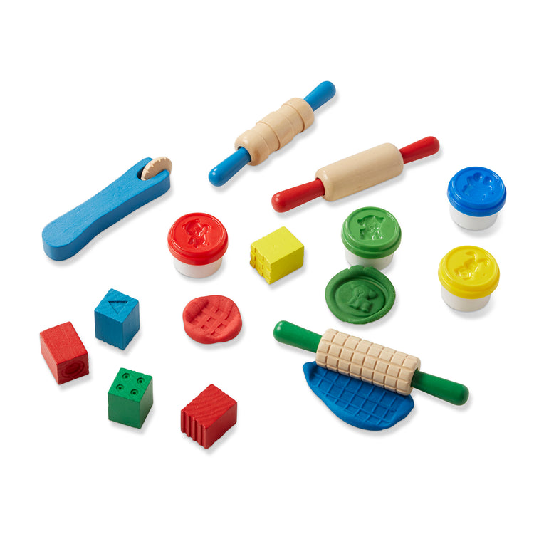 The loose pieces of The Melissa & Doug Shape, Model, and Mold Craft Activity Set - 4 Tubs of Modeling Dough and Tools